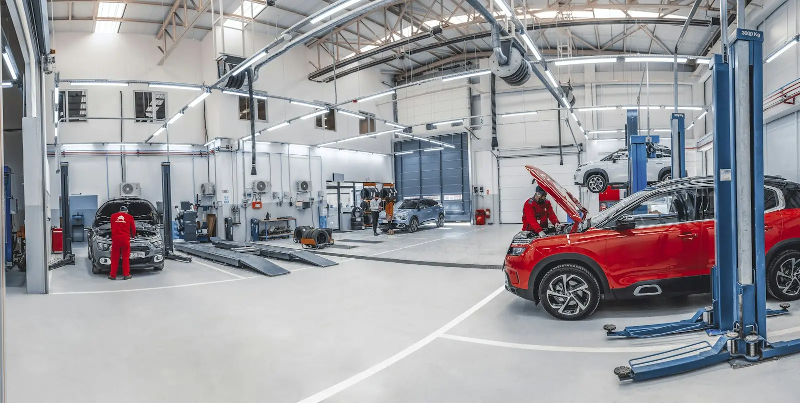 Inside a collision repair shop with cars on lifts