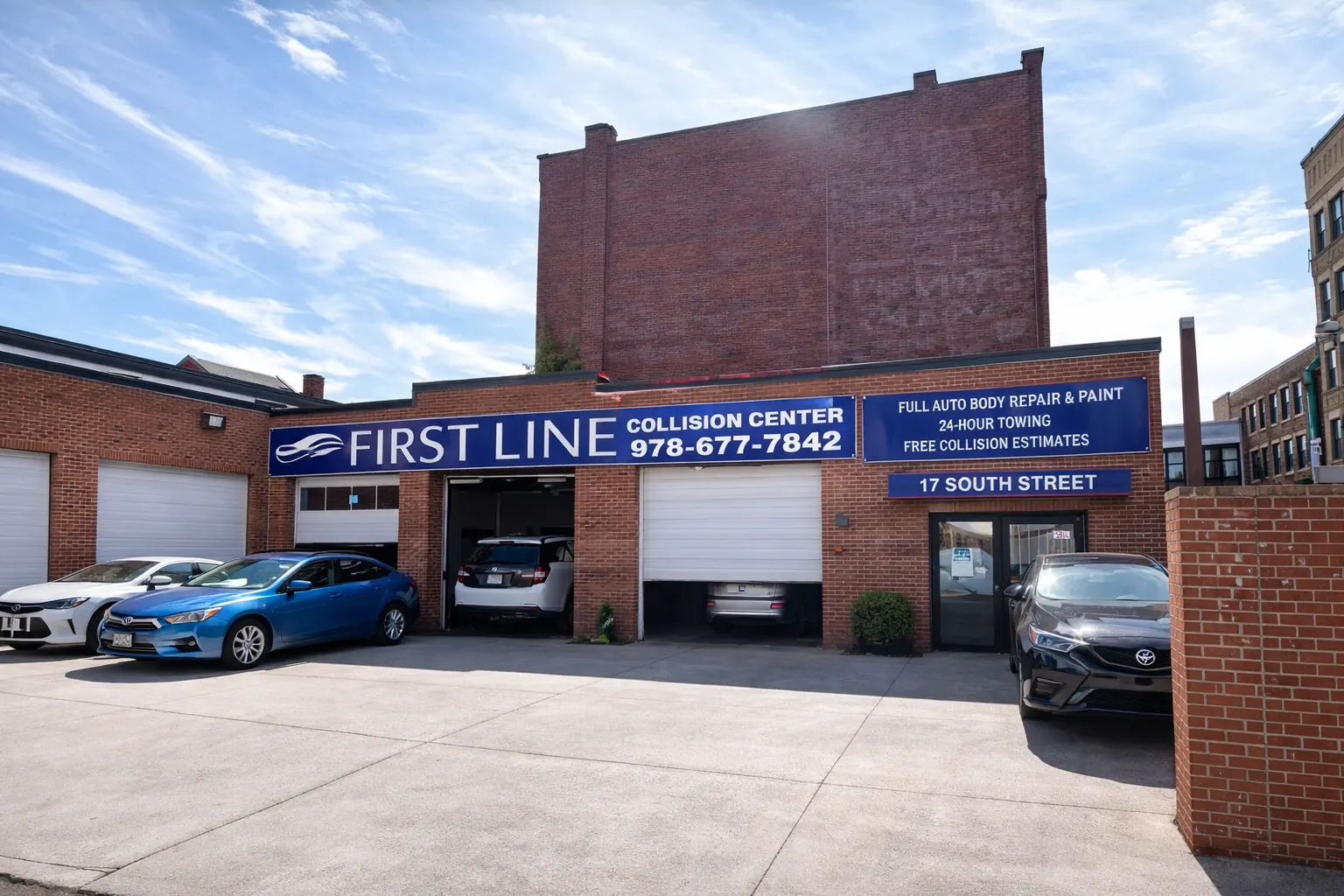 First Line Collision Center storefront at 17 South Street in Lowell, with open garage bays
